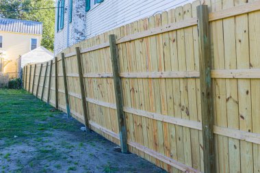 Wooden fence bent by winds from Hurricane Zeta in New Orleans, LA, USA clipart