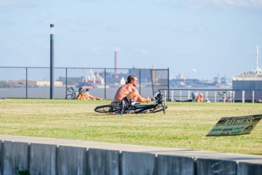 NEW Orleans, LA - 14 Kasım 2020: Güneşli bir günde Mississippi Nehri kıyısındaki Crescent Park 'ta yoga yapan adam