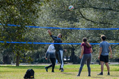YENİ ORLEANS, LA, ABD - 2 HAZİRAN 2021: Audubon Park 'ta kadın oyuncu ve topun yer aldığı voleybol oyunu