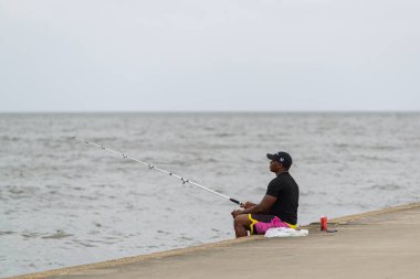 NEW ORLEANS, LA, ABD - 9 Ekim 2020: Pontchartrain Gölü 'nde balık tutan adam