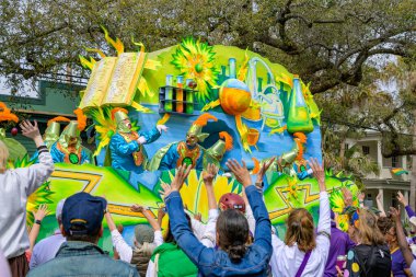 New Orleans, LA, ABD - 4 Mart 2025: Krewe of Rex Riders, Napolyon Bulvarı 'ndaki Mardi Gras Geçit Töreni sırasında kollarını sallayarak kalabalığa boncukları fırlattı