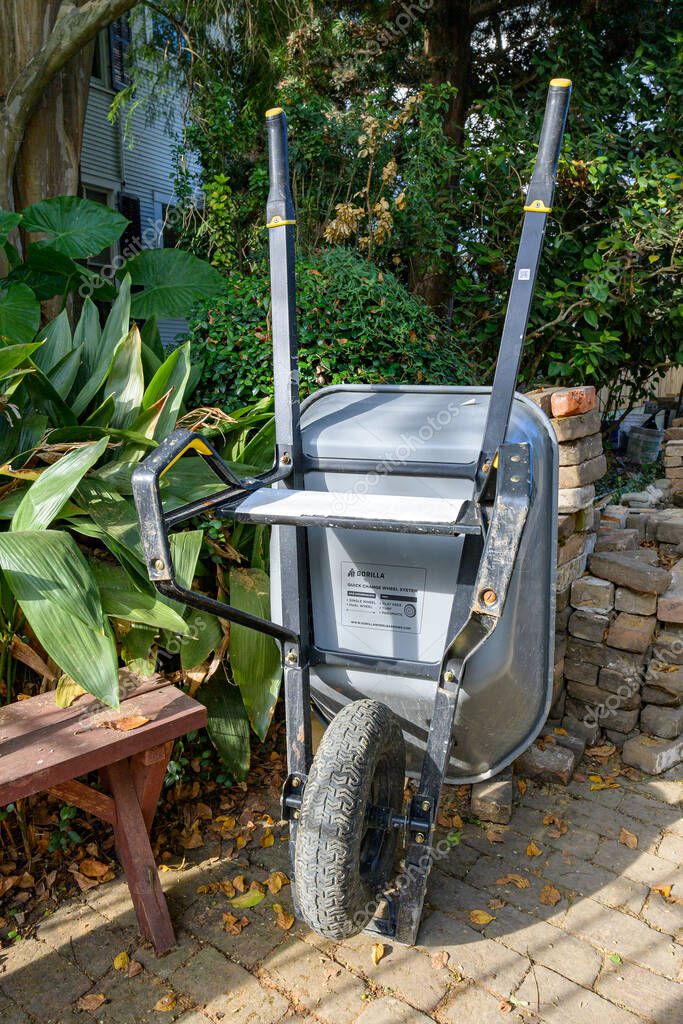 New Orleans, LA, USA - September 30, 2025: Gorilla brand wheel barrow stored in upright position in the patio of and historic house during a construction project