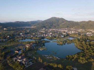 Gün doğumunda resimli dağların etrafındaki kır köyünün havadan görünüşü