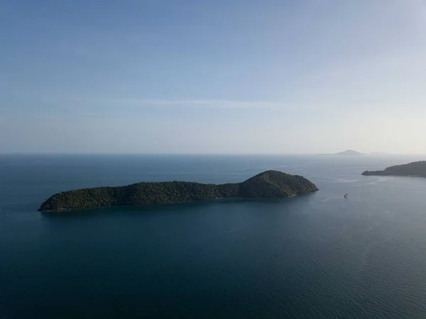 Tropikal ada, gün batımında gökyüzünden, dağdan, küçük serbest plajdan, Phuket şehrinin ve dağların arkasından. Seyahat konsepti