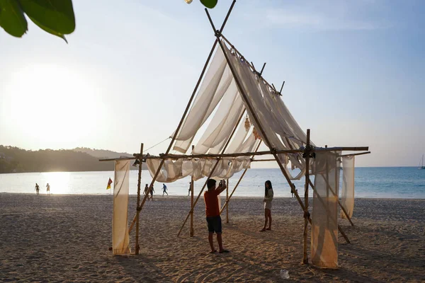 Patong plajı, Tayland, 08 Şubat 2021. Genç Asyalı çift sahildeki beyaz hava örtüsünün altında fotoğraf çekiyor. Yüksek kalite fotoğraf