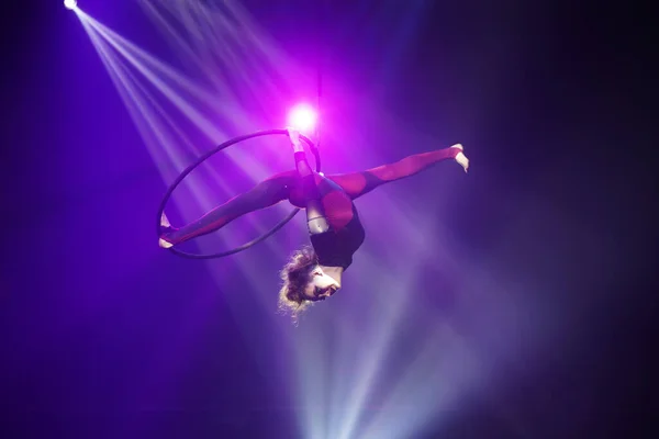 Esnek genç kadın hava çemberinde performans sergiliyor, hava çemberinde esnek bölünmeler, hava sirki gösterisi...