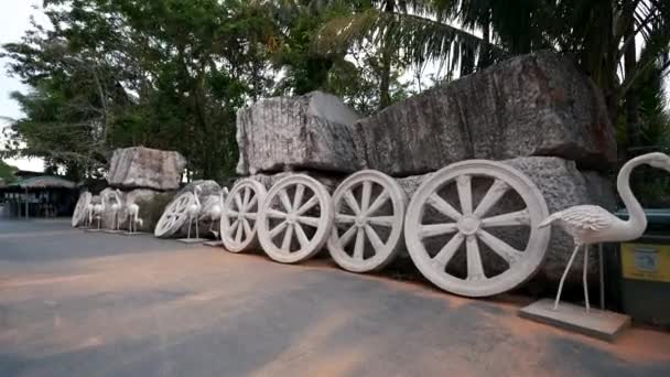 Flamingo statues, large stones, large concrete wheels. Near Big Buddha Phuket — Stock Video