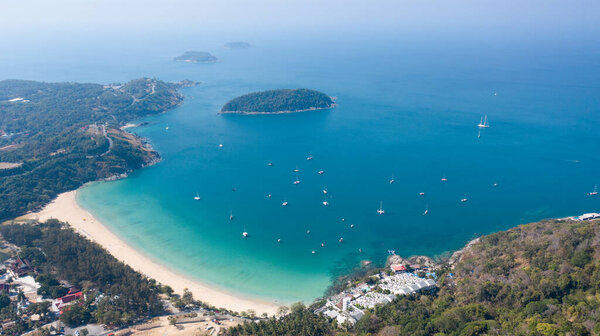 Aerial view of the tropical beach of Nai Harn and asphalt road along the coastline on Phuket island in Thailand