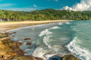 Okyanus dalgaları ve gün batımında hindistan cevizi palmiyesi olan tropik bir sahil. Sörf konsepti