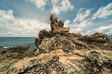 Pazar ışıklarıyla okyanus dalgalarıyla kayalık uçurum kıyısı