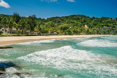 Close up sea waves on background of tropical beach with coconut palm tree and green hills. Summer vacation and nature travel adventure concept.. Summer composition.