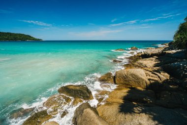 Rocky shore with beautiful blue color sea water and waves. Summer vacation and nature travel adventure concept.. Summer composition.