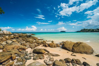 Beautiful and wild lonely beach with rough granite rocks, white sand, palm trees in a jungle and turquoise water of the indian ocean. Summer vacation and nature travel adventure concept.. Summer