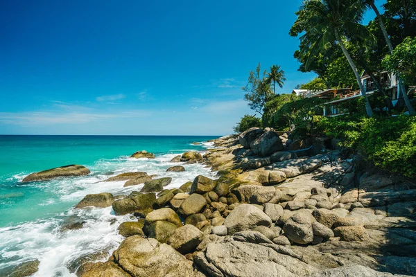 Waves hit rocky shore on sunny day and blue bright sky. Summer vacation and nature travel adventure concept.. Summer composition. — Stockfoto