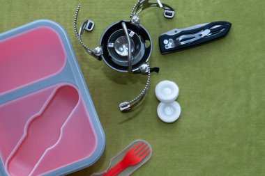 Açık hava için silikon kırmızı bir kap, bir bıçak ve taşınabilir bir soba.