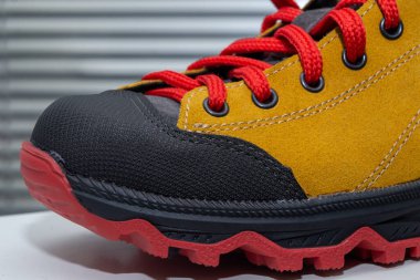 Sırt çantası için kırmızı bağcıklı sarı bir çizme.