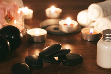 Sıcak masaj için siyah taşlar kaputun altında güzel pembe bir şakayık ve spa için diğer özellikler..