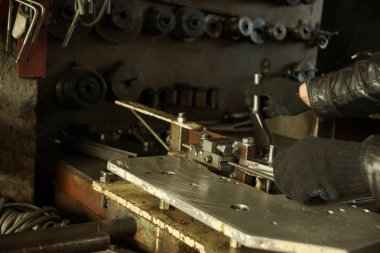 Çalışma makinesi ve eldiven giymiş işçi elleri..