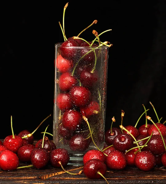 Glas Mit Reifen Kirschen Auf Dunklem Hintergrund Mit Wassertropfen — Stockfoto