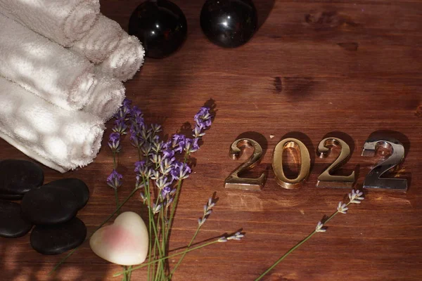 Números 2022 en la mesa junto a piedras de masaje caliente y toallas — Foto de Stock