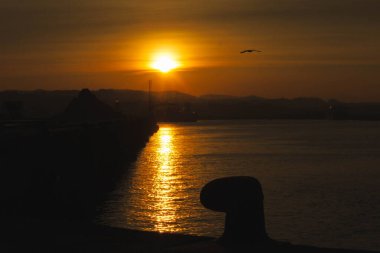 iskelede gün doğumu bir bollard ile