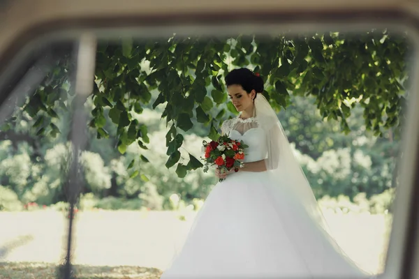 Чувственная брюнетка невеста с букетом — стоковое фото