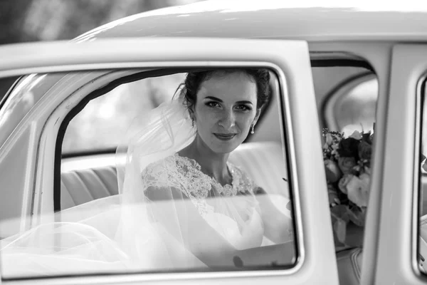 Hermosa novia morena sonriendo en coche — Foto de Stock