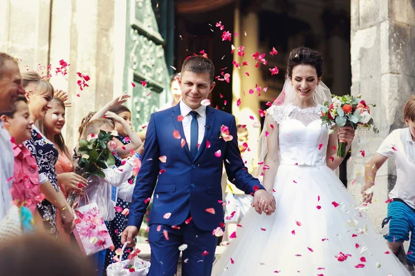 Yeni evli gelin ve damat kiliseden yürüyüş — Stok fotoğraf