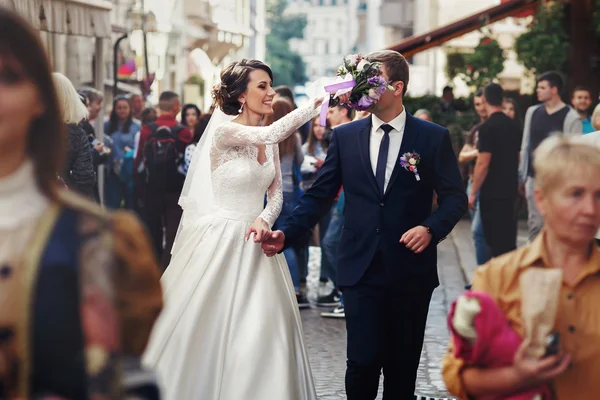 Gelukkig jonggehuwden wandelen in de stad — Stockfoto