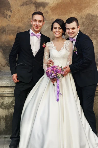 Two handsome groomsmen posing with bride — Stock Photo, Image