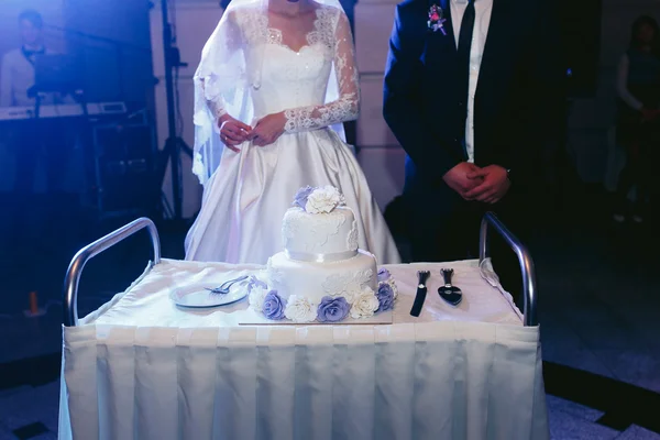 Feliz lindos recém-casados cortando delicioso bolo de casamento branco um — Fotografia de Stock