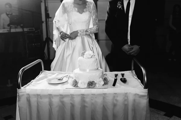 Feliz lindos recém-casados cortando delicioso bolo de casamento branco um — Fotografia de Stock