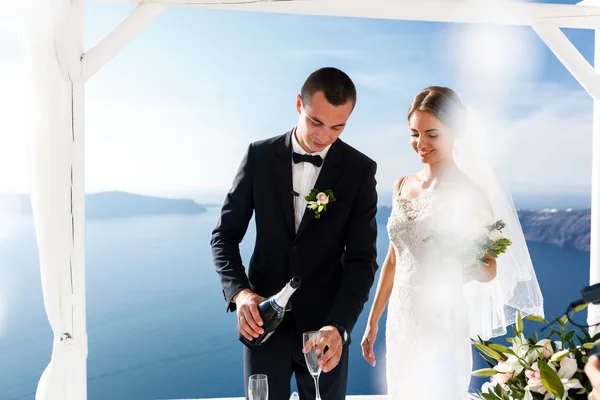 Groom and bride opening champagne — Stock Photo, Image