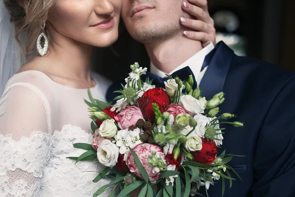 Schöner Bräutigam umarmt glückliche Braut — Stockfoto