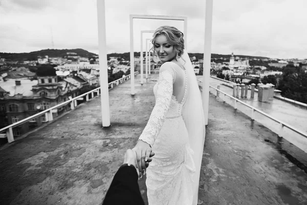 Mooie blonde bruid toonaangevende bruidegom — Stockfoto