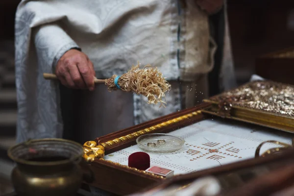 Priest baptizing wedding rings — Stock Photo, Image