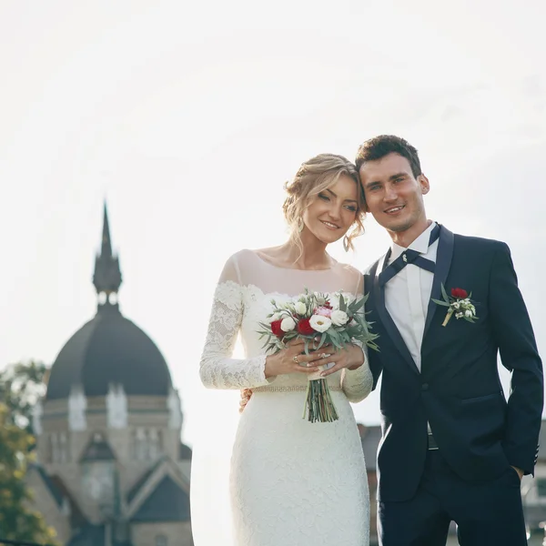 Feliz recém-casados posando ao pôr do sol — Fotografia de Stock