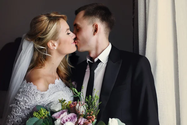Romantic newlyweds kissing in hotel — Stock Photo, Image