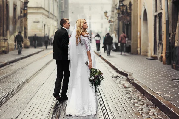 Sposi che camminano lungo la vecchia strada — Foto Stock