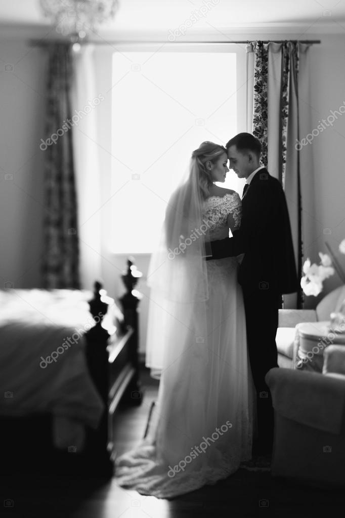 Romantic newlyweds kissing in hotel