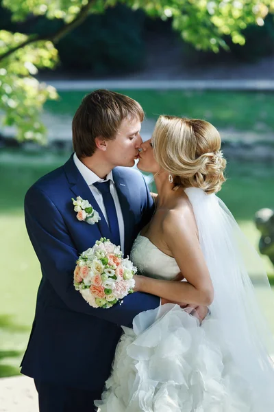 Romantische jonggehuwde paar zoenen in park — Stockfoto