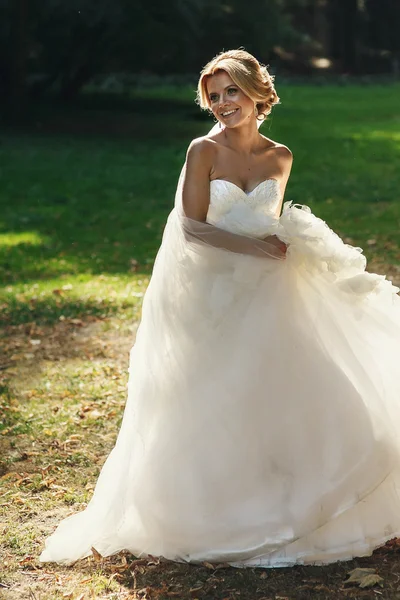Счастливая красивая невеста танцует в парке — стоковое фото