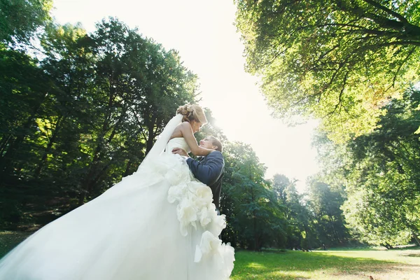 Forte sposo tenendo bella sposa — Foto Stock