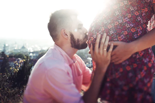 幸せな男は妻の妊娠中の腹にキス — ストック写真