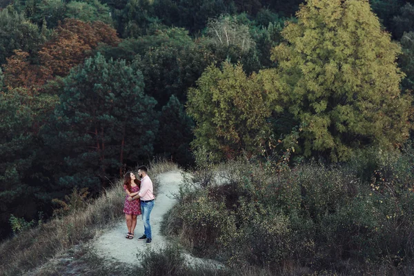 Man en zwangere vrouw knuffelen in bos — Stockfoto