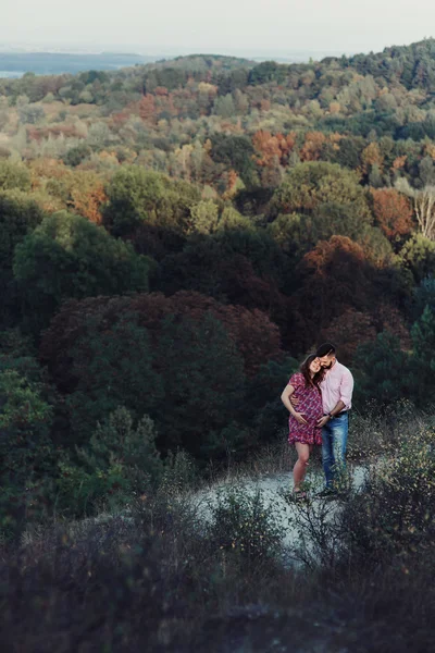 Man en zwangere vrouw knuffelen in bos — Stockfoto