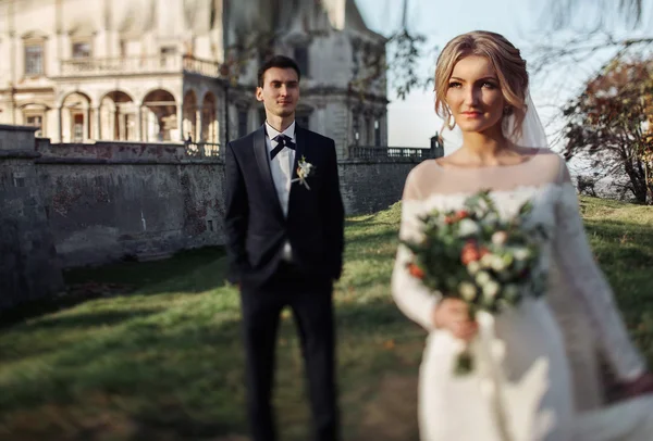 Великолепная невеста с букетом и красивым женихом — стоковое фото