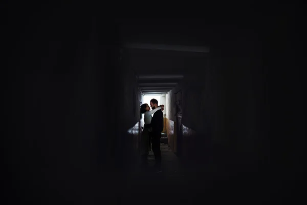 Couple hugging in dark hallway — Stock Photo, Image