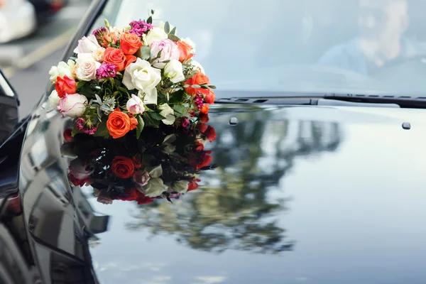 Beautiful wedding bouquet on black car — Stock Photo, Image