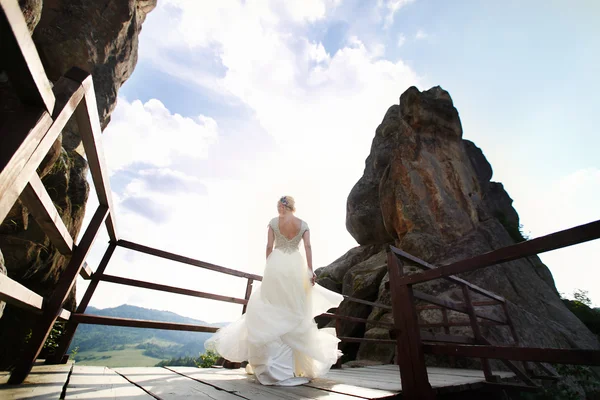 Mariée tourne entre les montagnes contre le ciel — Photo